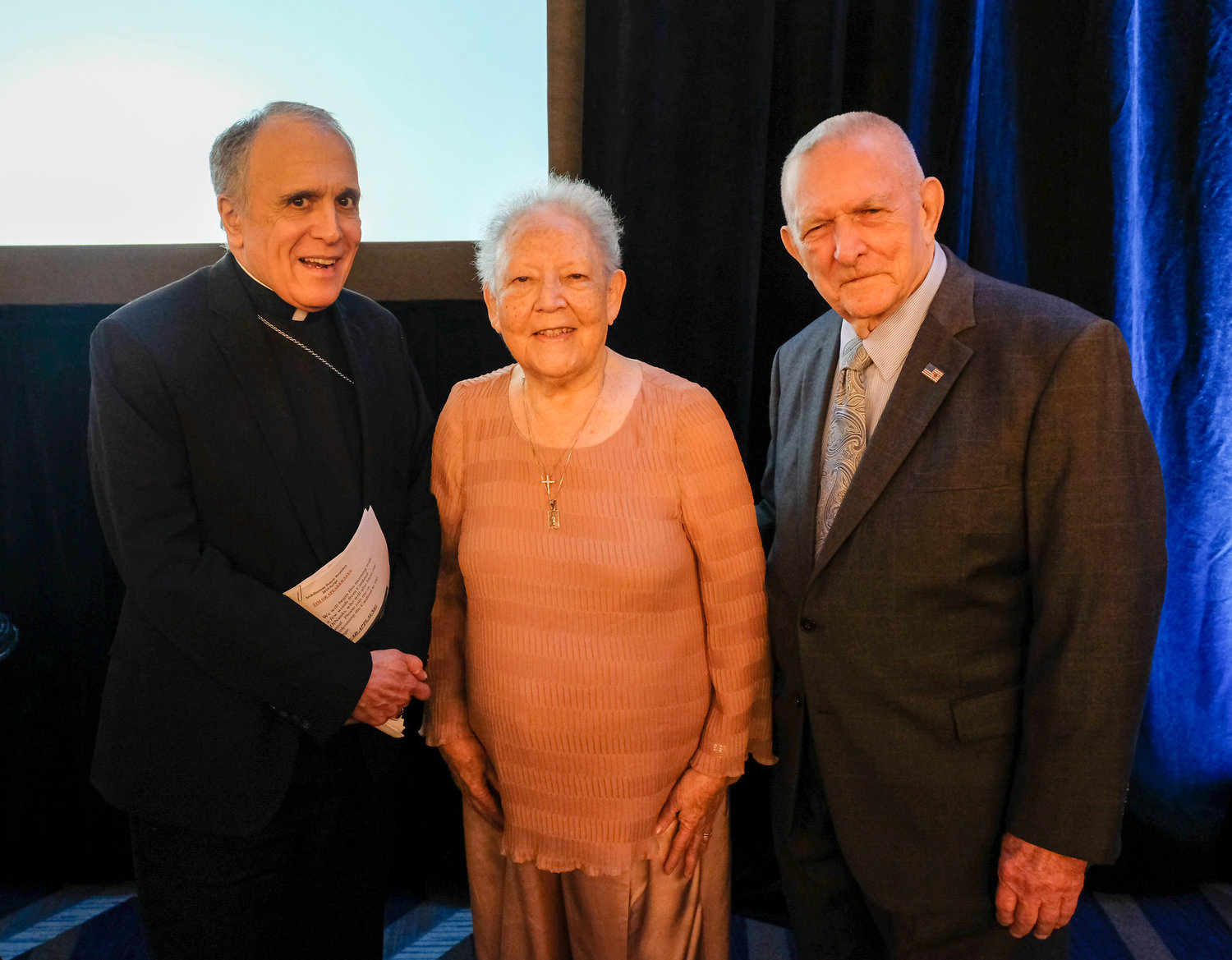 Cardinal Daniel N. DiNardo of Galveston-Houston poses with Gene Kranz, right, former flight director for Apollo 11, and his wife, Marta, during the 2019 Archdiocese of Galveston-Houston Prayer Breakfast in Houston July 30. Gene Kranz, who served as the event’s speaker, is a parishioner at Shrine of the True Cross Catholic Church in Dickinson, Texas, near Houston.
